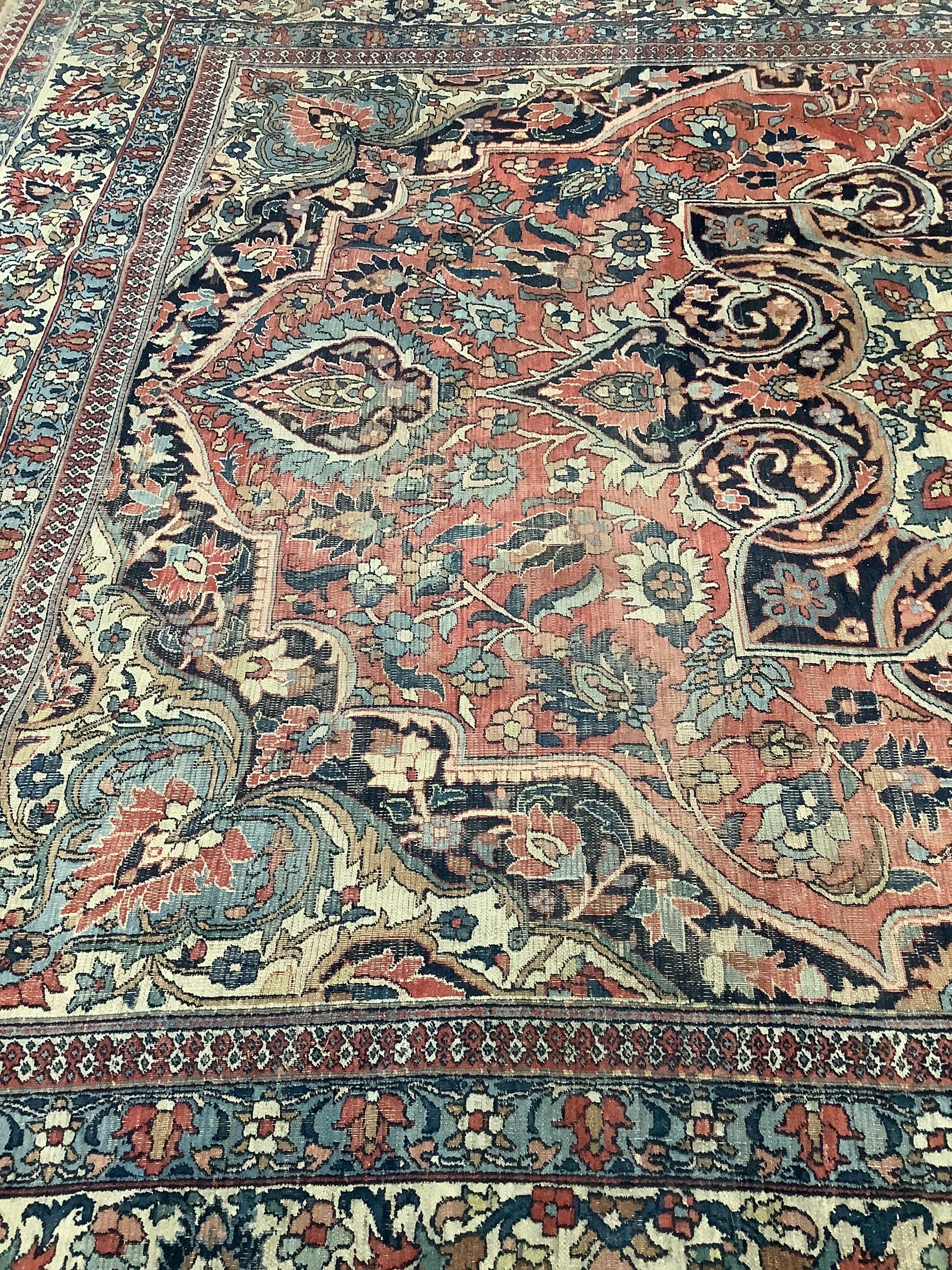 An early 20th century Heriz burgundy ground carpet, 380 x 276cm